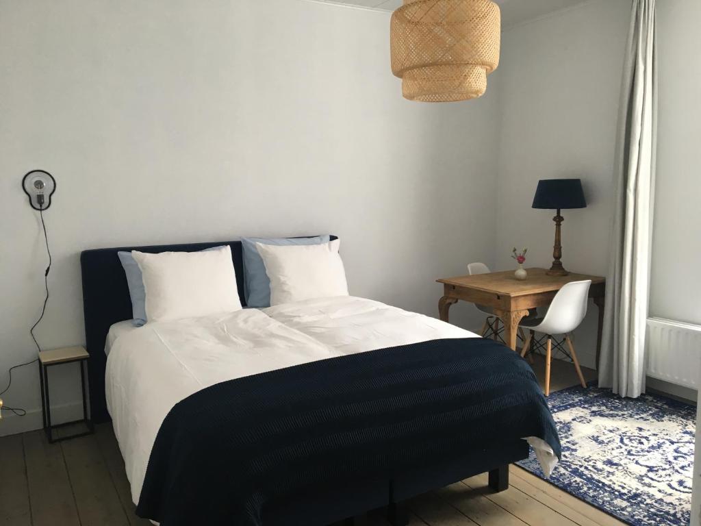 een slaapkamer met een zwart-wit bed en een tafel bij NineT7 in Tilburg