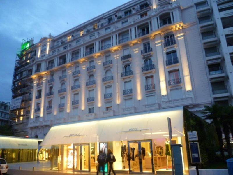 - un grand bâtiment blanc avec des personnes marchant devant dans l'établissement Studio Croisette, à Cannes