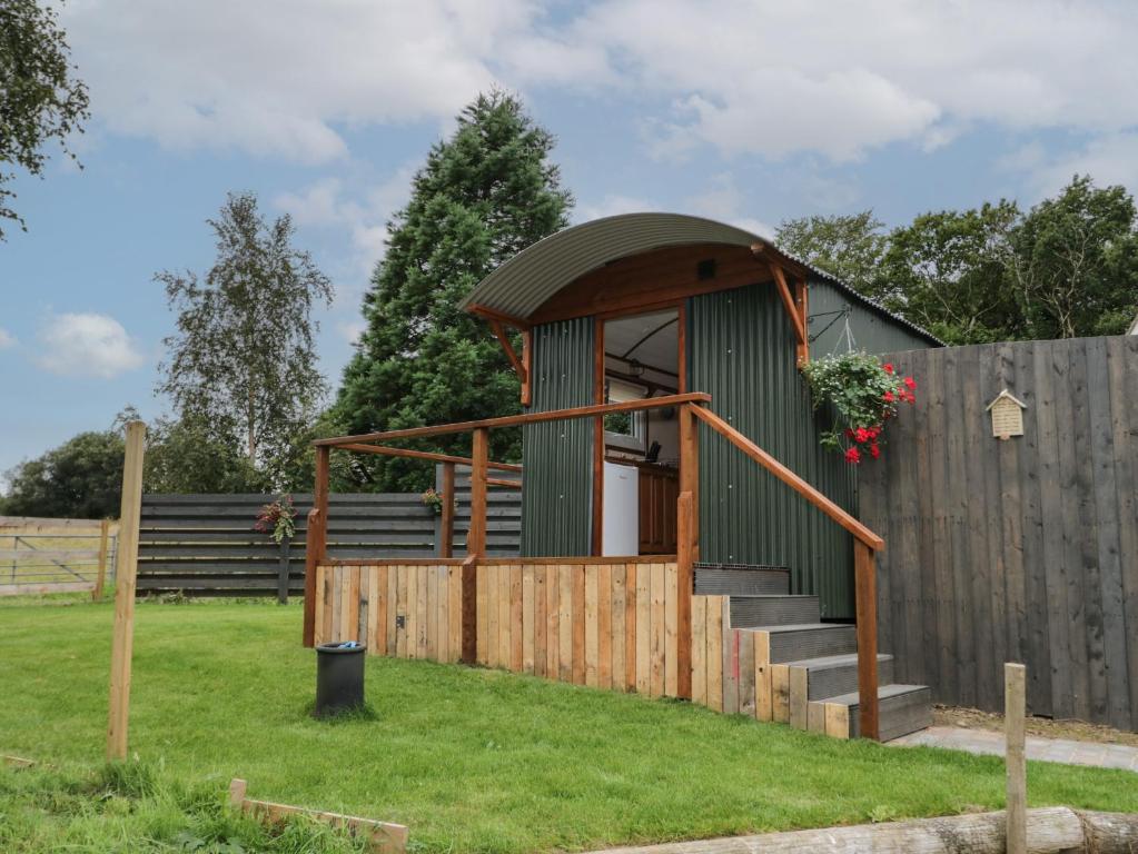 eine kleine Hütte in einem Hof mit einem Zaun in der Unterkunft Glyder Fach in Bangor
