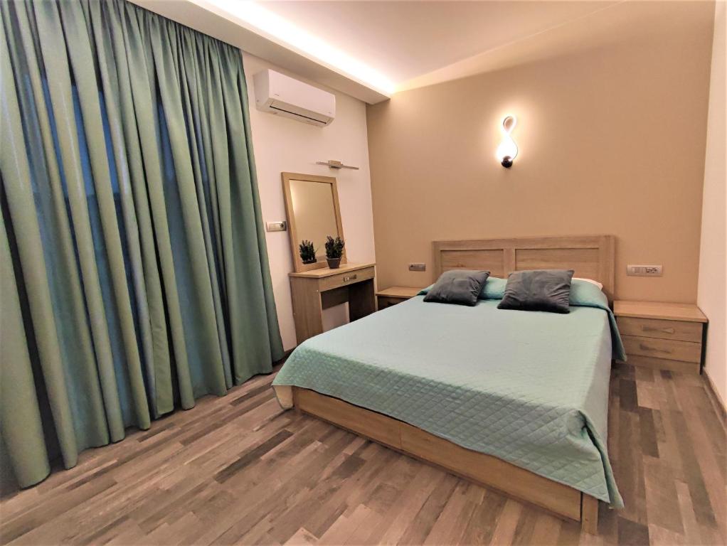 a bedroom with a large bed and green curtains at Villa Pavlina in Ixia
