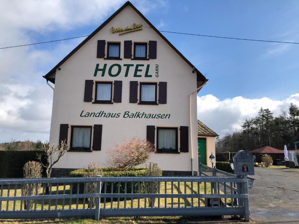 a hotel with a sign on the side of a building at Landhaus Balkhausen in Nürburg