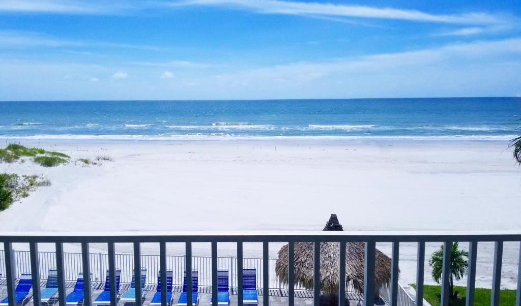 a view of a beach with blue chairs and the ocean at Sea Oats by Liberte Management in St Pete Beach
