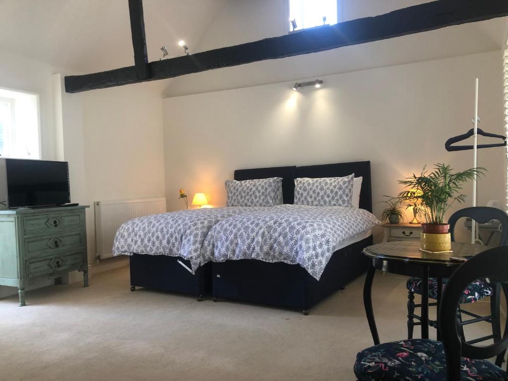 a bedroom with a bed and a table and a television at Brooks House formerly The Red Lion in St Margarets at Cliff