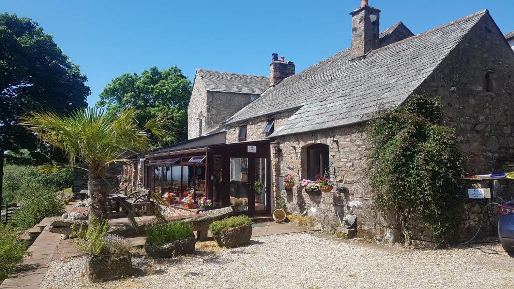 an old stone building with a store in front of it at Windsor Farm House near Scafell in Nether Wasdale