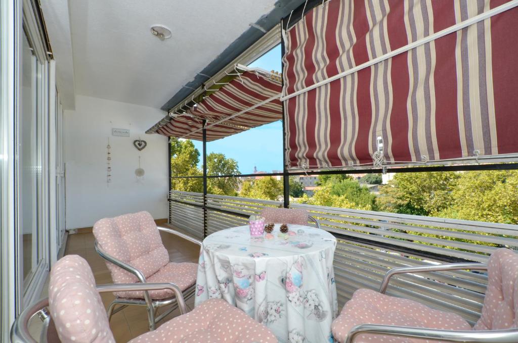 balkon ze stołem i krzesłami oraz oknem w obiekcie Apartman Lazy Summer Days w Splicie