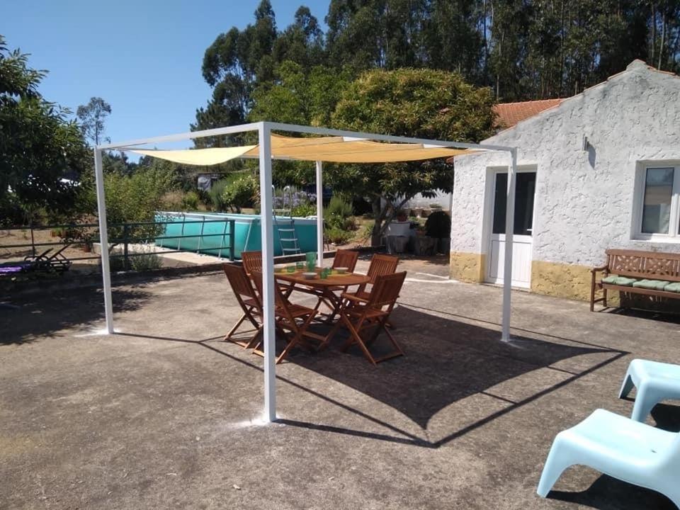 a patio with a table and an umbrella at Quinta da Mesa in Macinhata do Vouga