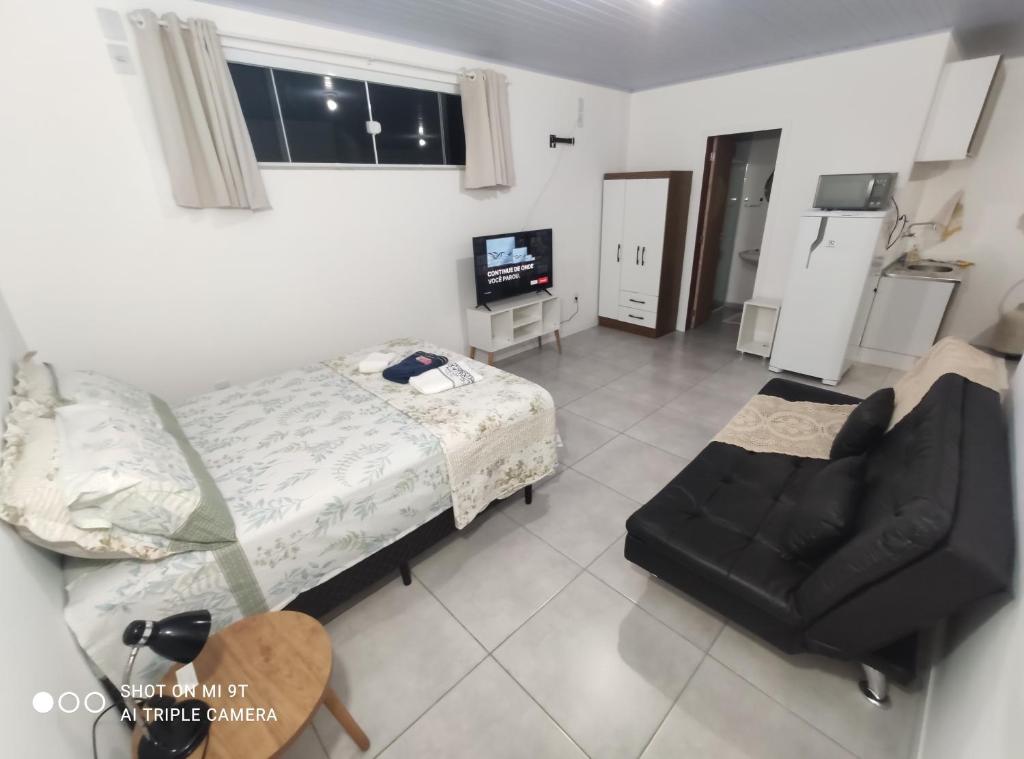 a view of a room with a bed and a chair at Casa em Florianópolis in Florianópolis