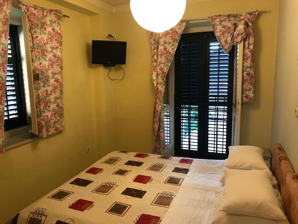 a bedroom with a bed and two windows and a television at Studio in the top center in Split