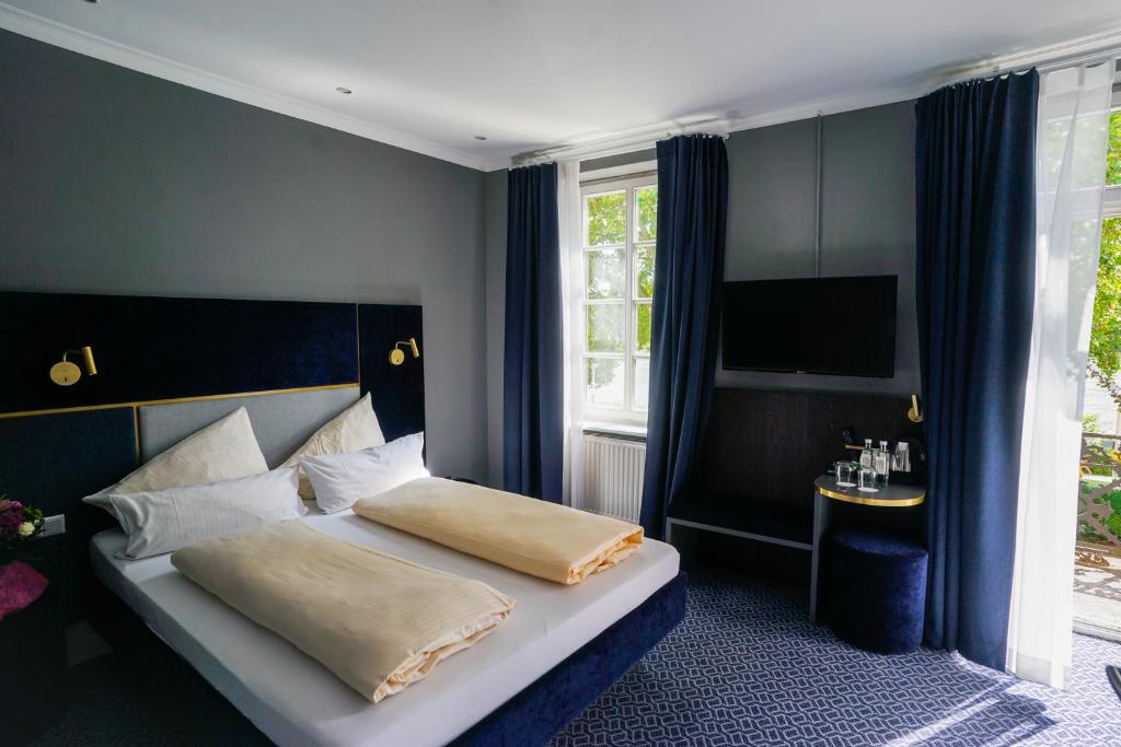ein Schlafzimmer mit einem Bett und einem TV in der Unterkunft Hotel Am Schloss Biebrich in Wiesbaden