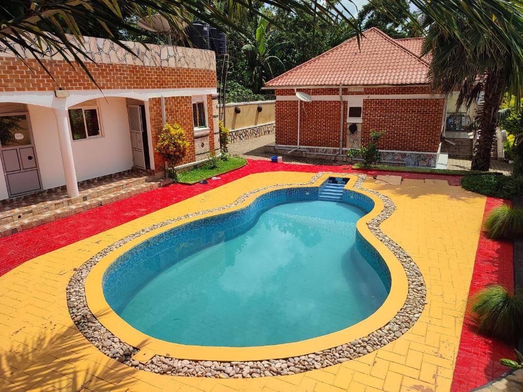 a swimming pool in front of a house at HEDGE GUEST HOUSE in Kampala