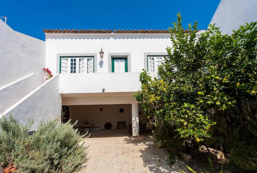 una casa blanca con un patio con árboles en Casa da Paz, en Labrugeira