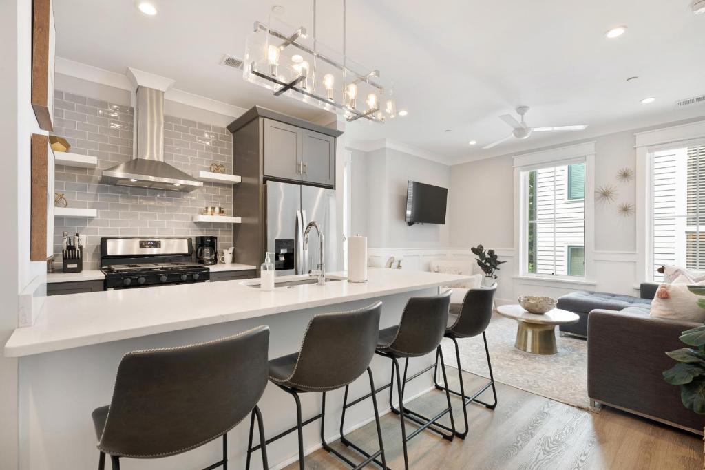 a kitchen and living room with a bar and chairs at The Palm Suite at 124 Spring in Charleston