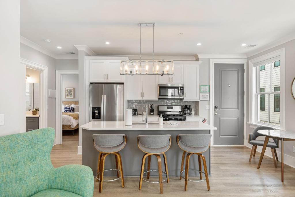a kitchen with a island with bar stools at The Cooper Suite at 122 Spring in Charleston