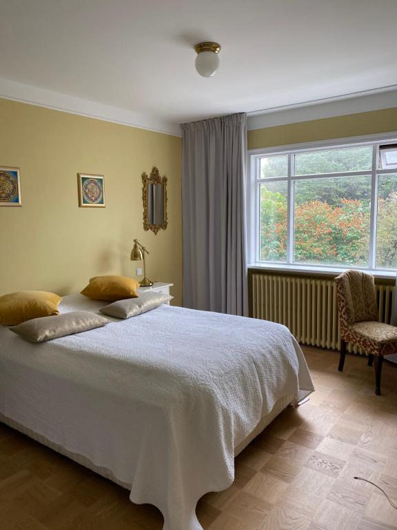Un dormitorio con una gran cama blanca y una ventana en Casa Dísa - Dreams, A Boutique Guesthouse in Reykjavik City`s Central Park and Botanical Garden in Laugardalur, Hot-Spring-Valley, en Reikiavik