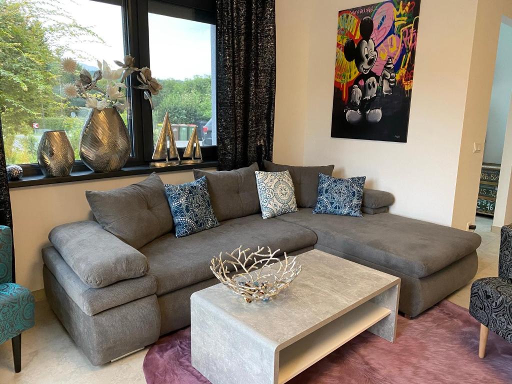 ein Wohnzimmer mit einem braunen Sofa und einem Tisch in der Unterkunft ZEITLOS in Velden in Velden am Wörthersee
