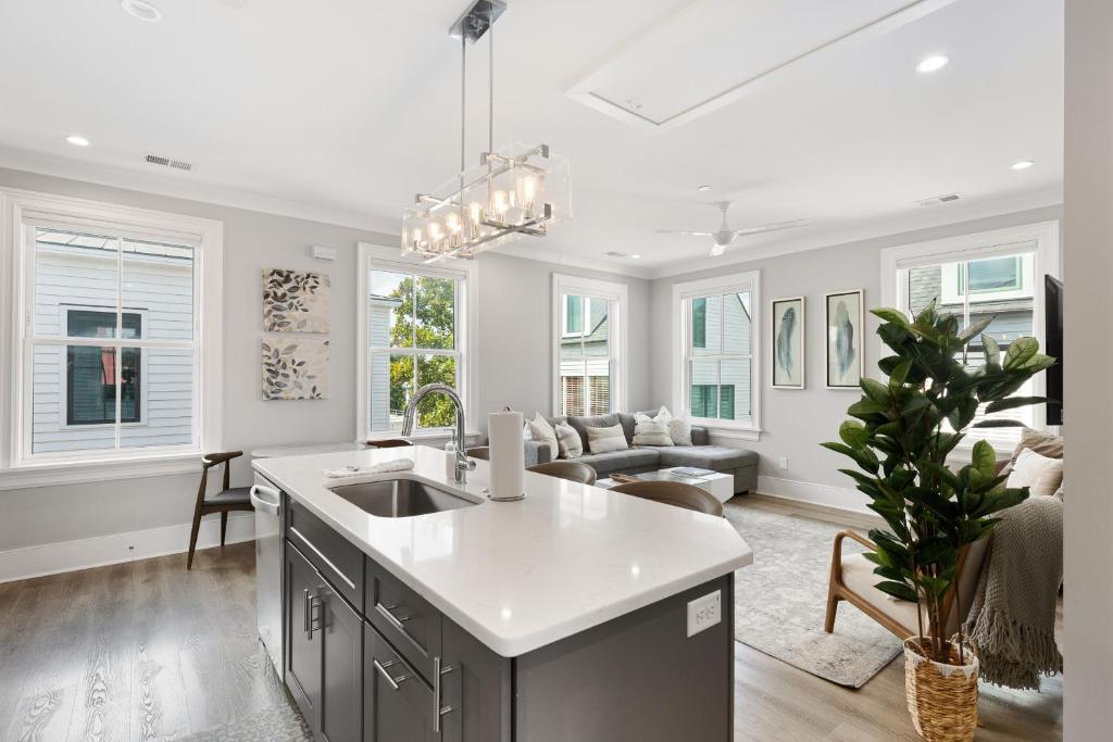 a kitchen with a sink and a living room at The Santee Suite at 122 Spring in Charleston