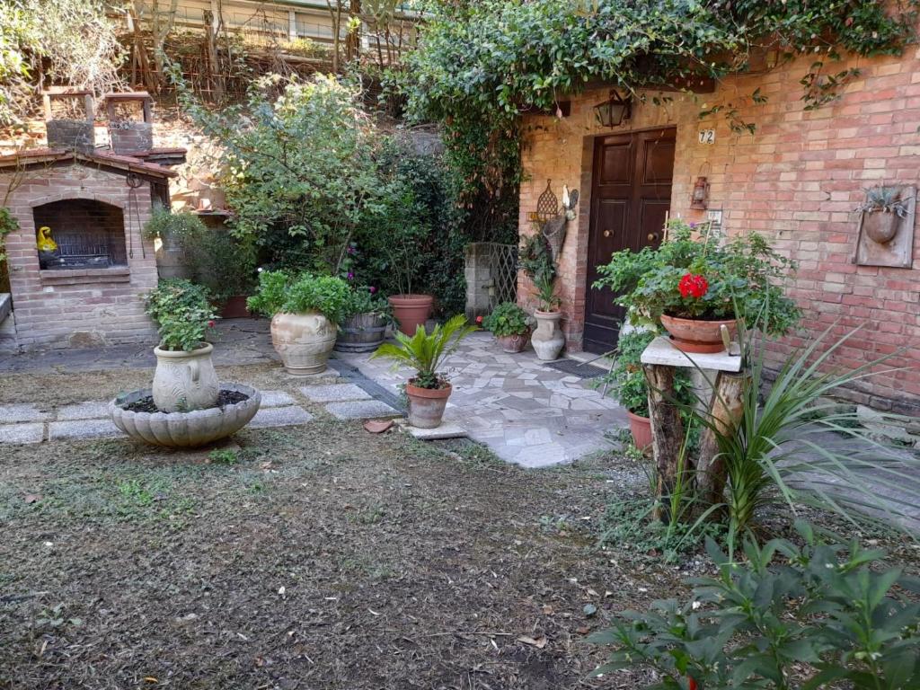einen Garten mit Topfpflanzen vor einem Gebäude in der Unterkunft Casa Patti alle porte di Siena in Siena