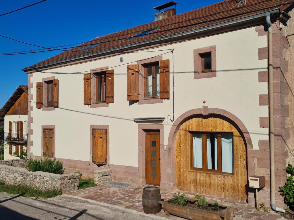 Cette maison ancienne est dotée de portes et de fenêtres en bois. dans l'établissement Ferme des molieres avec espace détente, à Mortagne