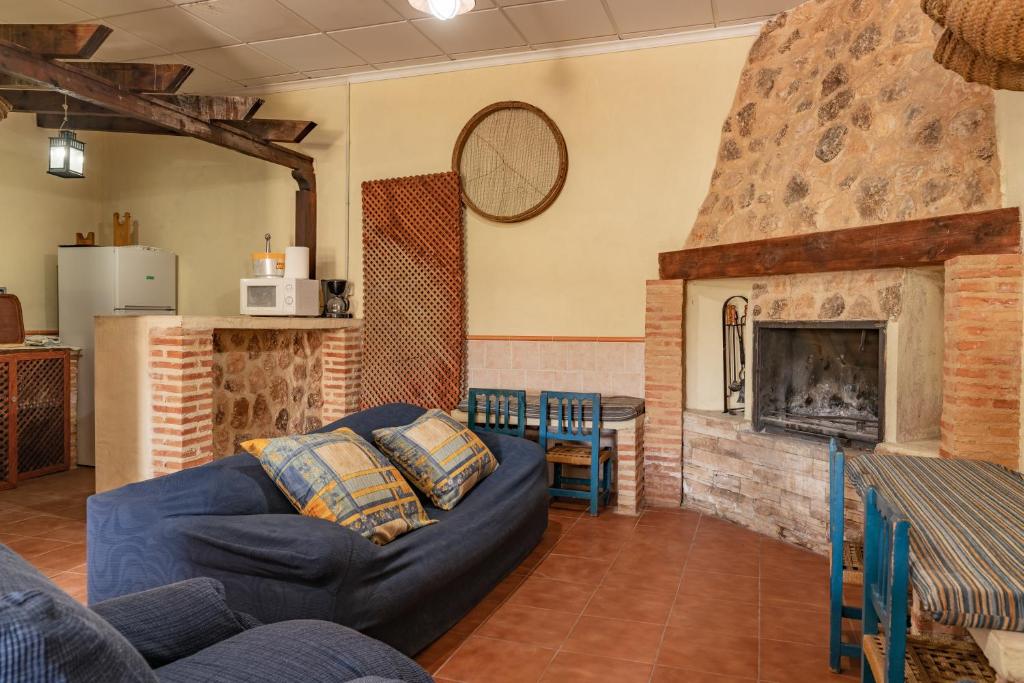 sala de estar con sofá azul y chimenea en Casas rurales Los Guerrero B, en Peñarrubia