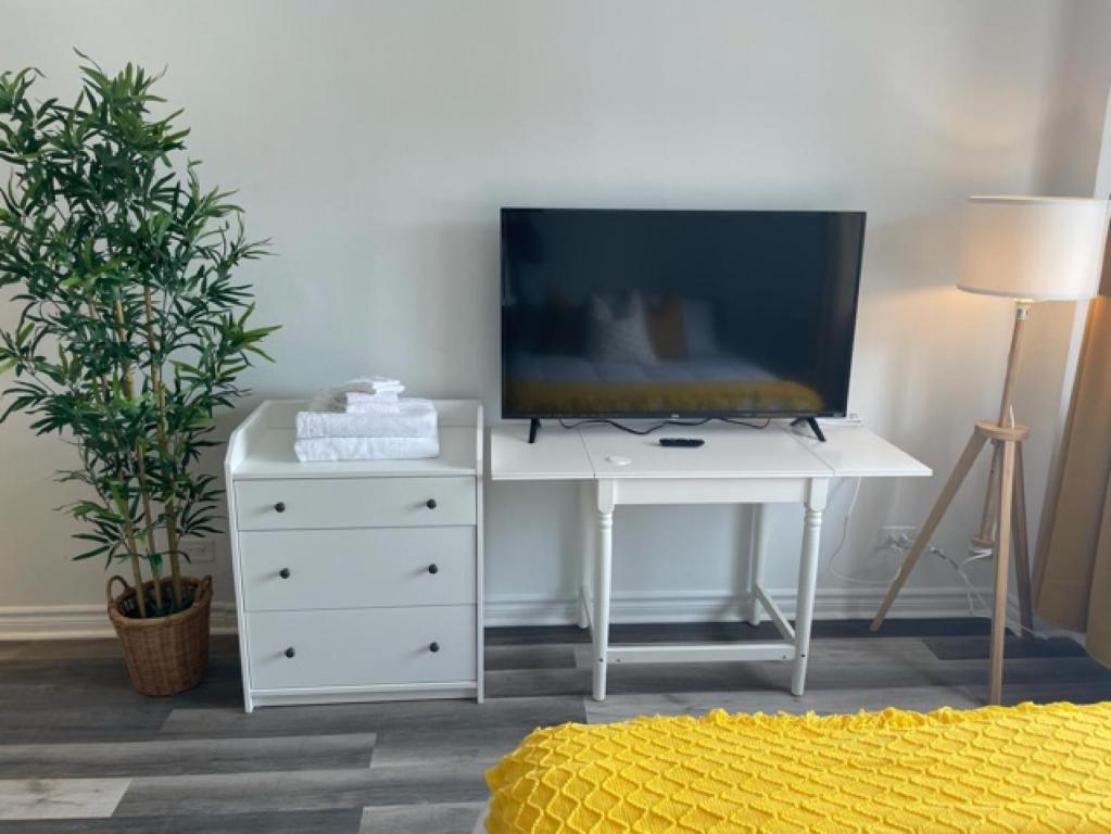 a white desk with a television on top of it at Faubourg Ste Cath in Montreal