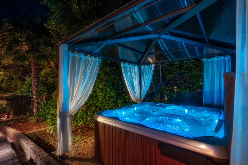 a blue hot tub in a backyard at night at Seaside Holiday Home Lily in Njivice