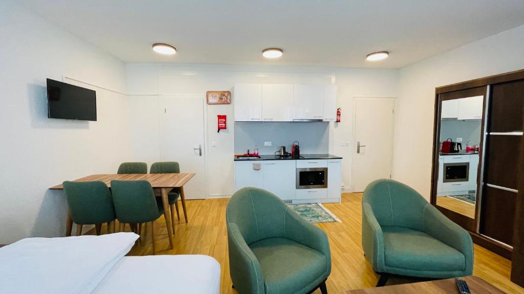 a living room with a table and chairs and a kitchen at Akomo Bern in Bern