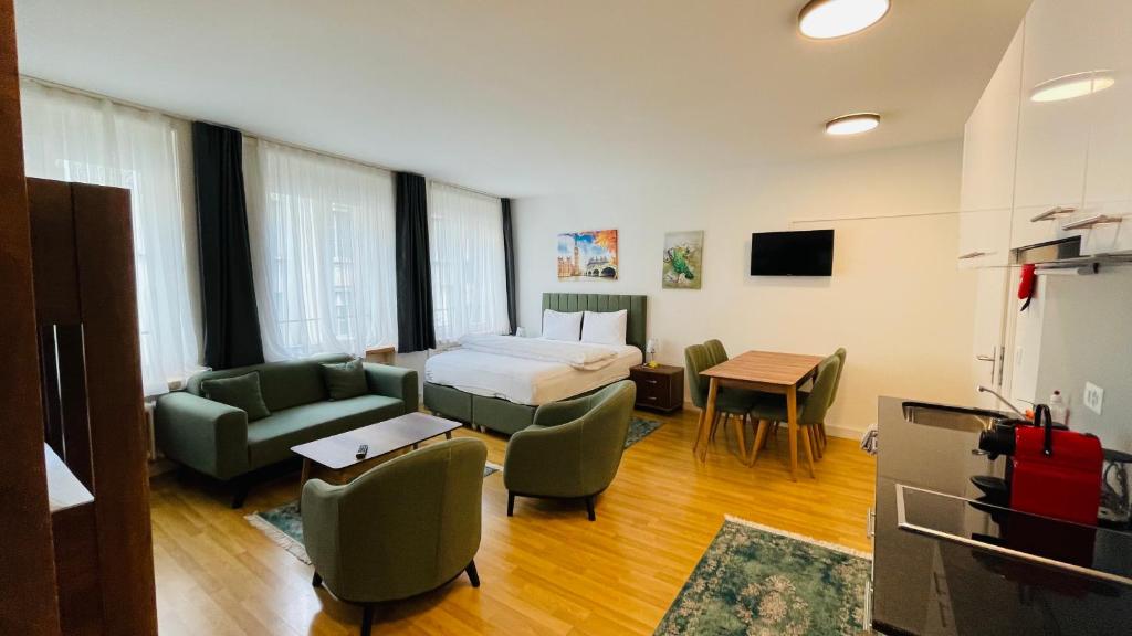 a bedroom with a bed and a couch and a table at Akomo Bern in Bern