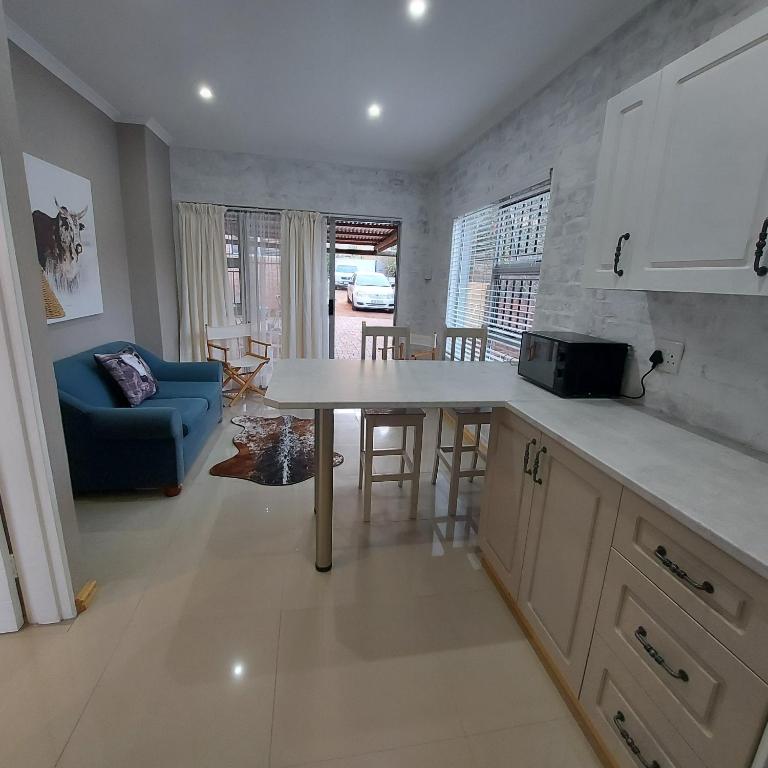 a kitchen and living room with a table and a couch at Bergsig 2A in Clanwilliam