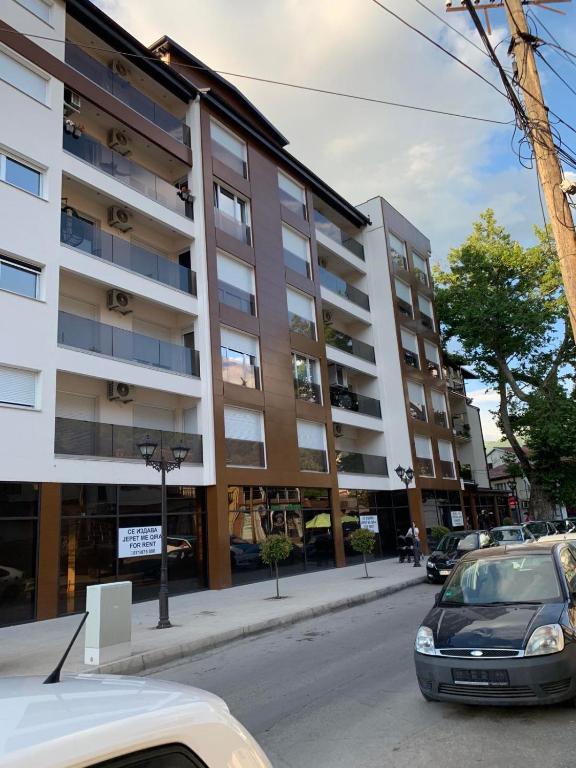 un'auto parcheggiata davanti a un grande edificio di LYNX Apartments a Ohrid