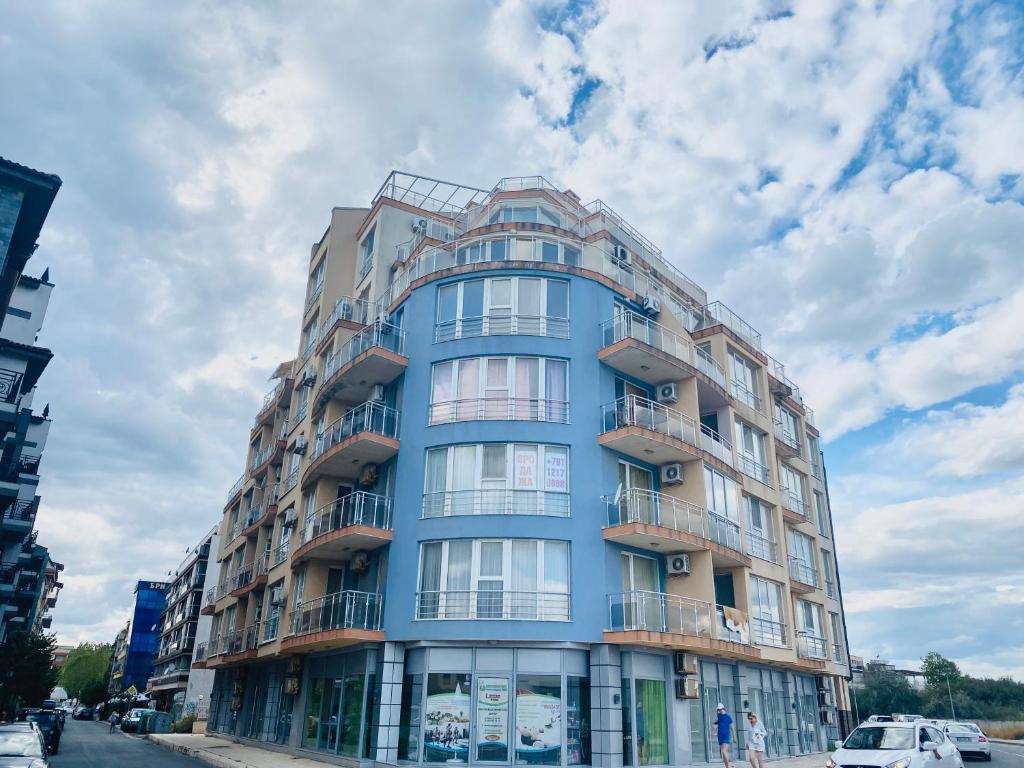 a blue building on a city street with cars at Golden Sea View 2 in Pomorie
