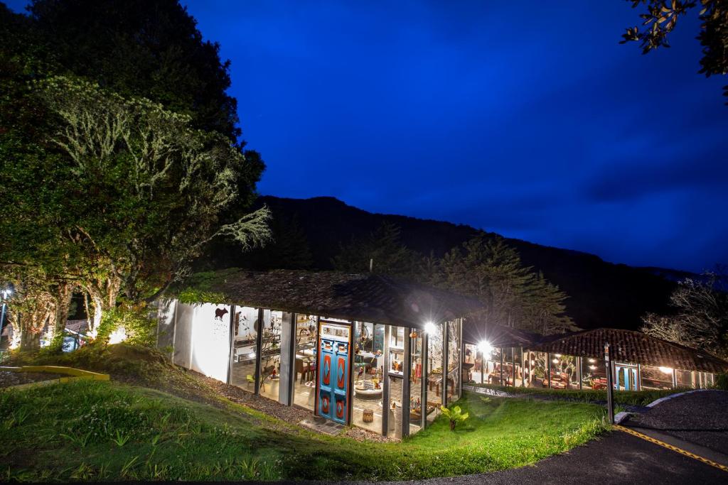 a building with a lot of signs on it at night at Dantica Cloud Forest Lodge in San Gerardo de Dota