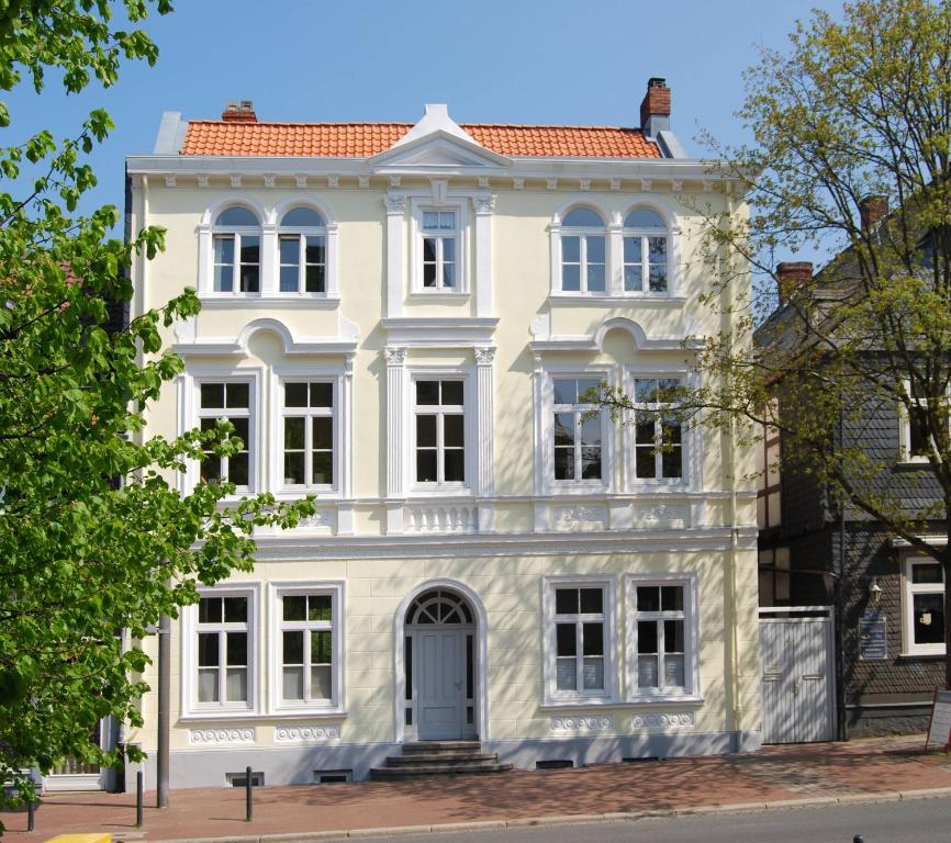 ein weißes Haus mit rotem Dach in der Unterkunft Ferienwohnungen an der Kaiserpfalz in Goslar