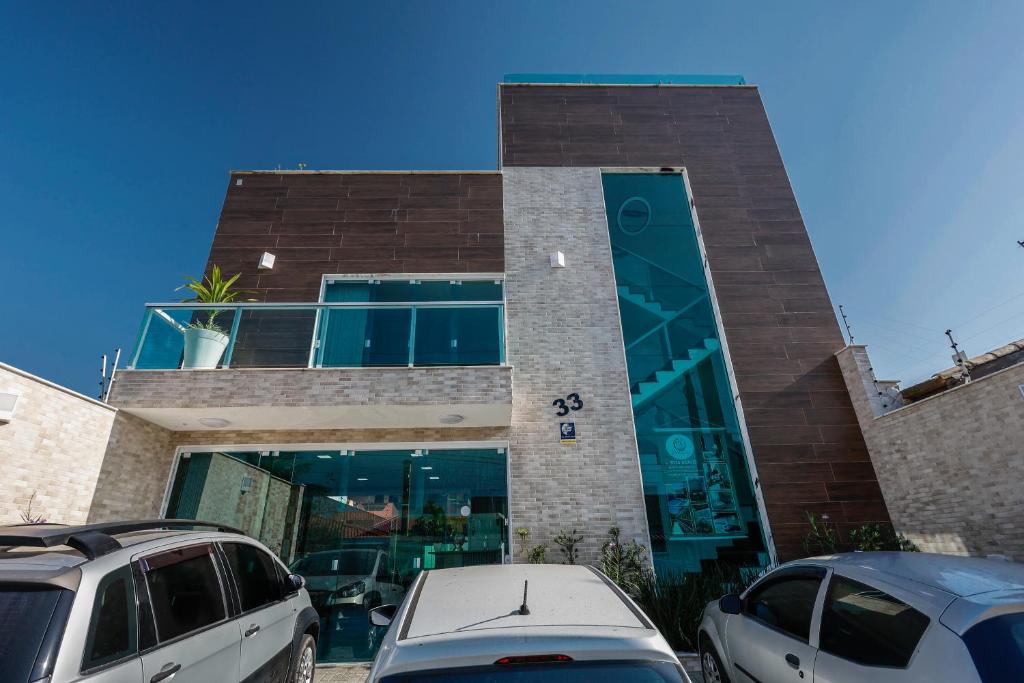 a building with cars parked in front of it at Pousada Peruibiza in Peruíbe