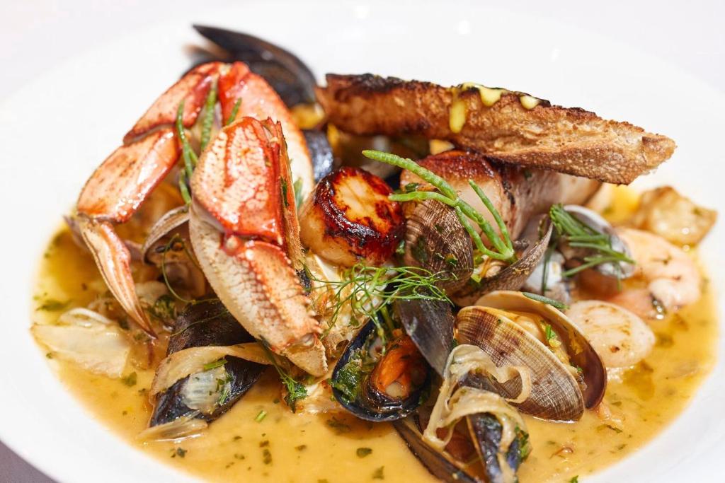 a plate of food with mushrooms and other foods at Hotel Le Soleil by Executive Hotels in Vancouver