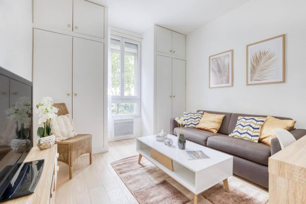 a living room with a couch and a coffee table at Superbe appartement tout près de Paris in Alfortville