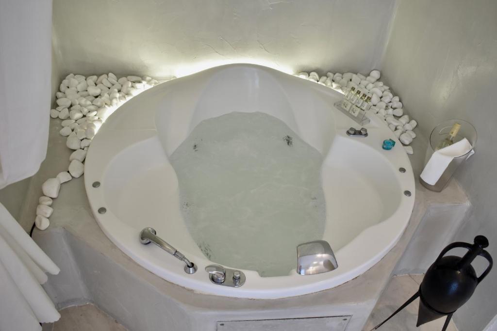 a white toilet in a bathroom with a roll of toilet paper at Aeolos Art & Eco Suites Adults Only in Imerovigli