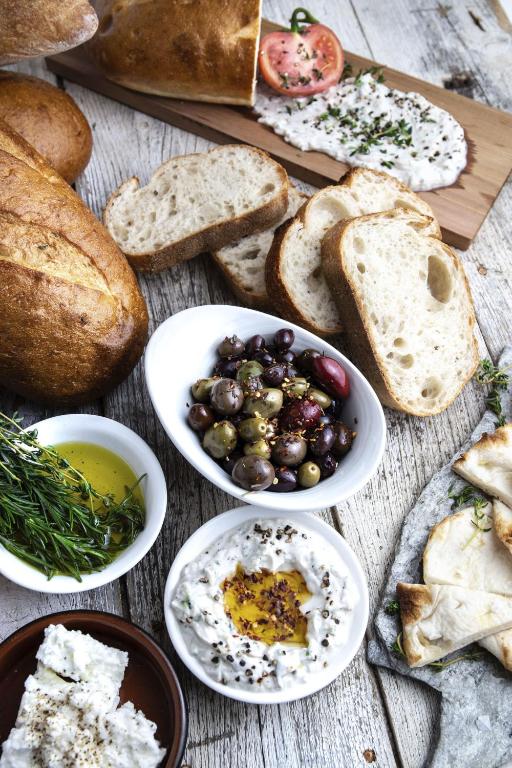 a table with different types of bread and plates of food at EXchange Hotel Vancouver in Vancouver