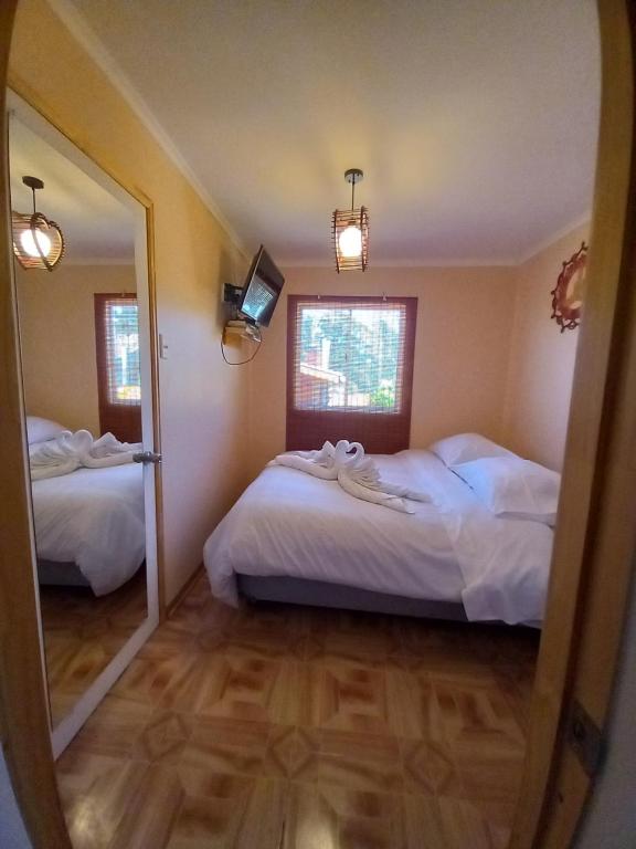 a bedroom with two beds and a mirror at Cabañas Kimaya El Quisco in El Quisco