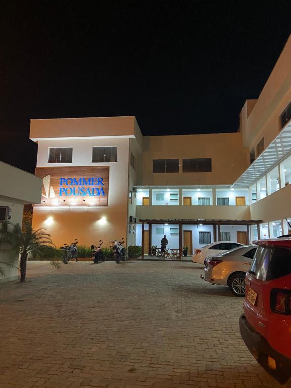 un estacionamiento frente a un hotel por la noche en POMMER POUSADA en Guriri