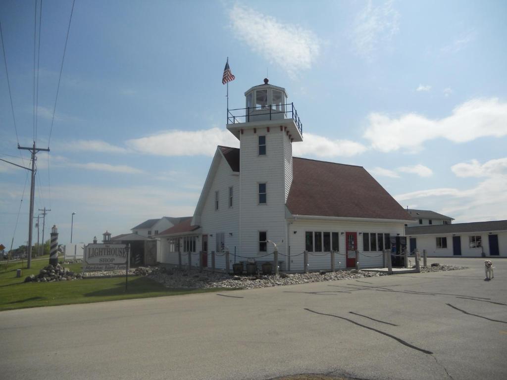 a white building with a lighthouse on top of it at Coho Motel in Kewaunee