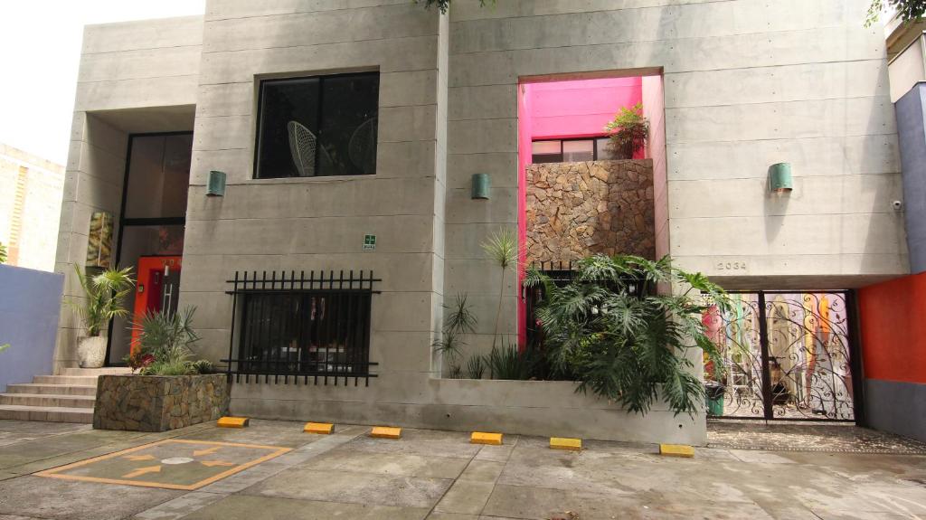 a building with a pink door and some plants at Ekléctic Hotel Boutique in Guadalajara
