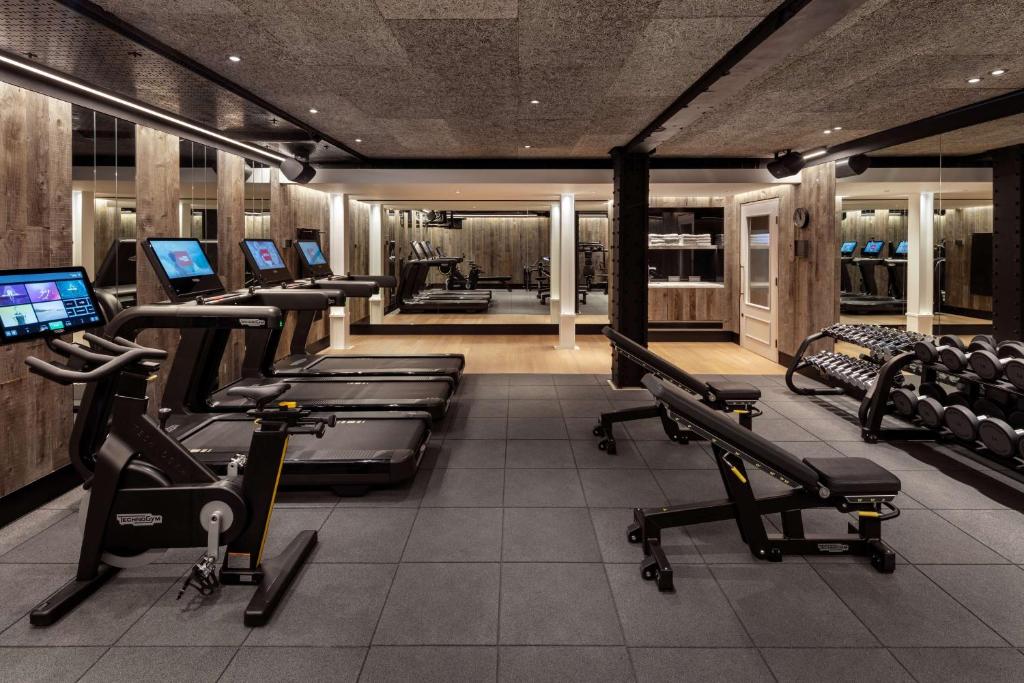 a gym with rows of treadmills and exercise machines at Radisson Blu Hotel, London Bloomsbury in London