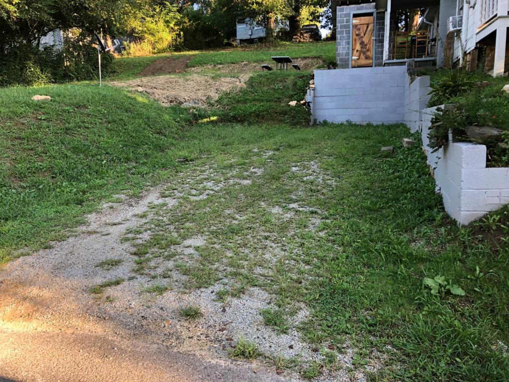 a yard next to a house with a dirt road at Cochran Farm House in Bryson City