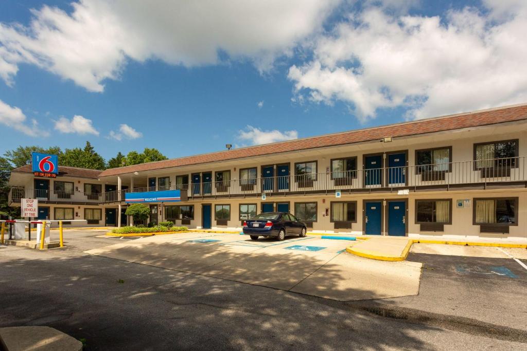 un bâtiment avec une voiture garée sur un parking dans l'établissement Motel 6-Camp Springs, DC - South Camp Springs, à Camp Springs