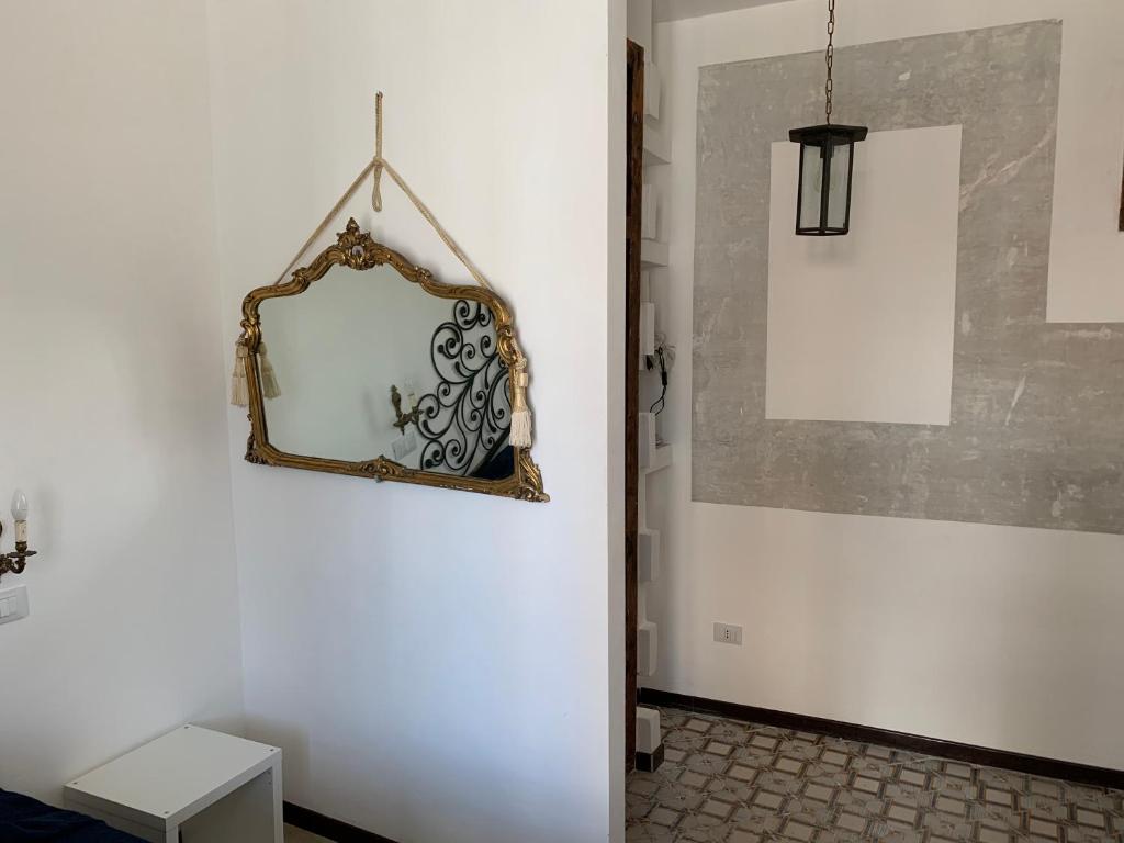 lustro wiszące na ścianie w pokoju w obiekcie FraLePorte Vintage Apartment w mieście Palermo