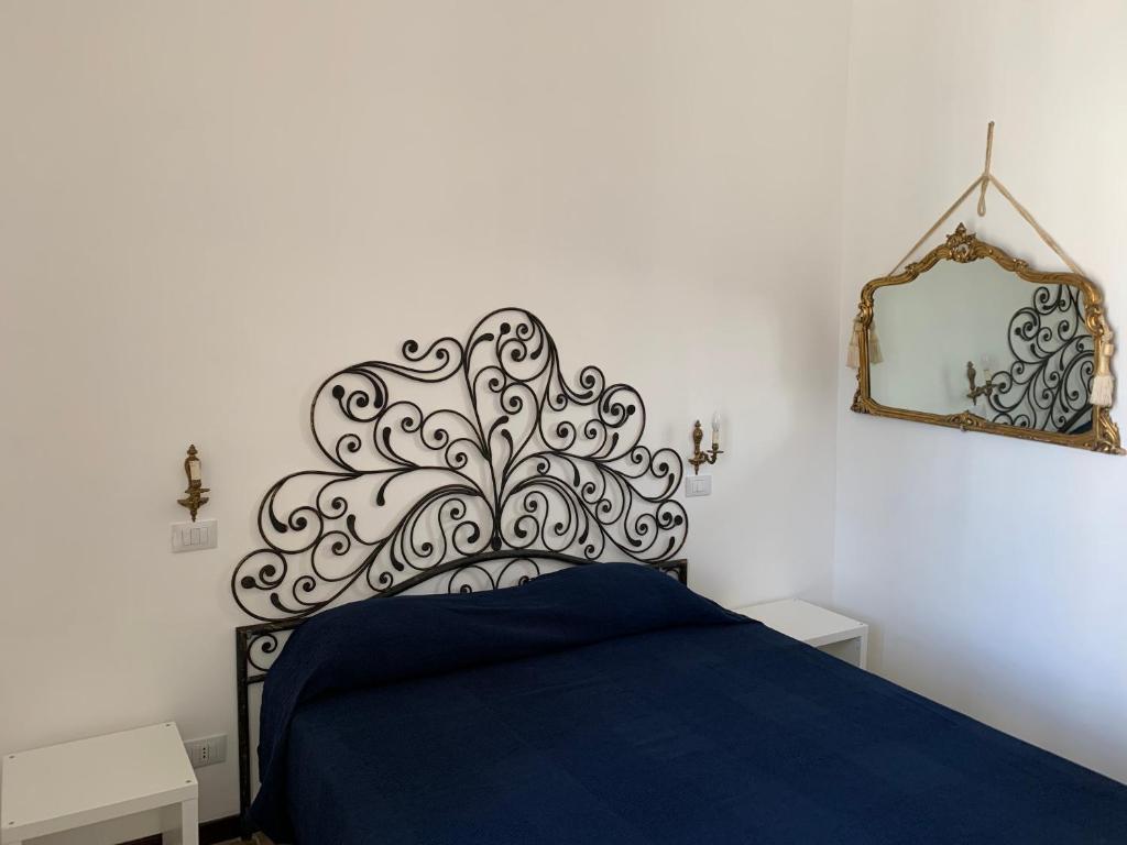 sypialnia z niebieskim łóżkiem i lustrem w obiekcie FraLePorte Vintage Apartment w mieście Palermo