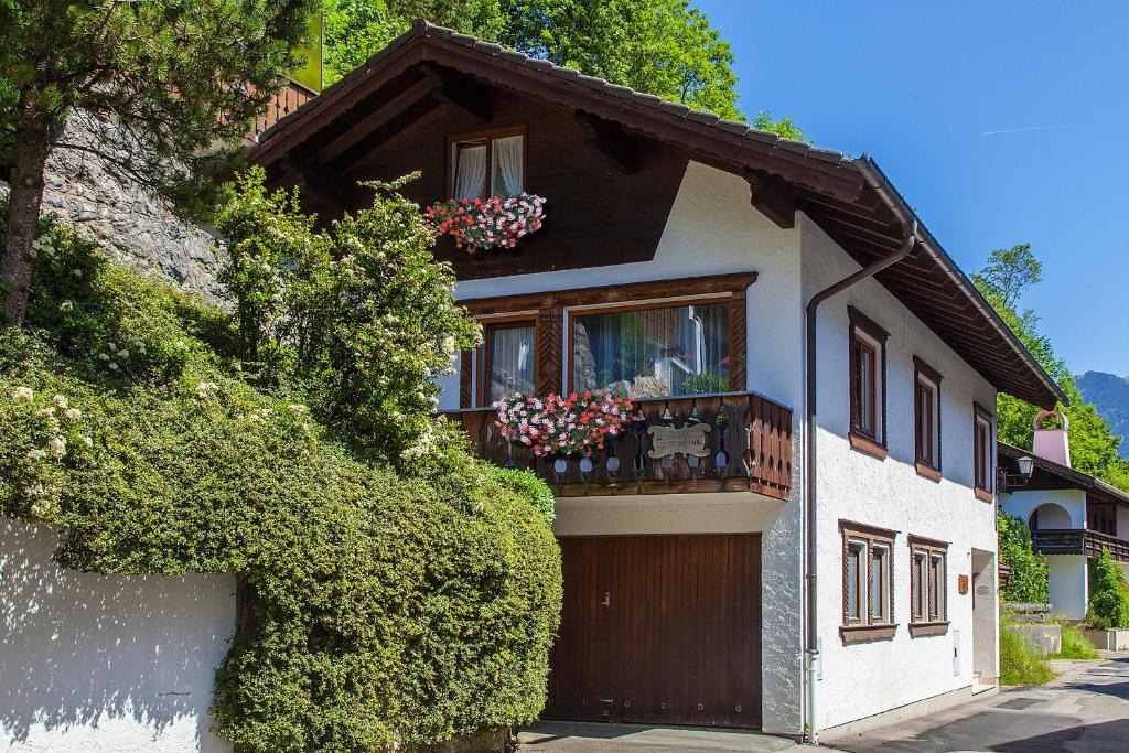 a house with a balcony with flowers on it at Haus Bader in Mittenwald