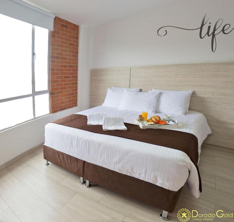 ein Schlafzimmer mit einem großen Bett und einem Tablett mit Obst darauf in der Unterkunft Hotel Bestmark Platino in Bogotá