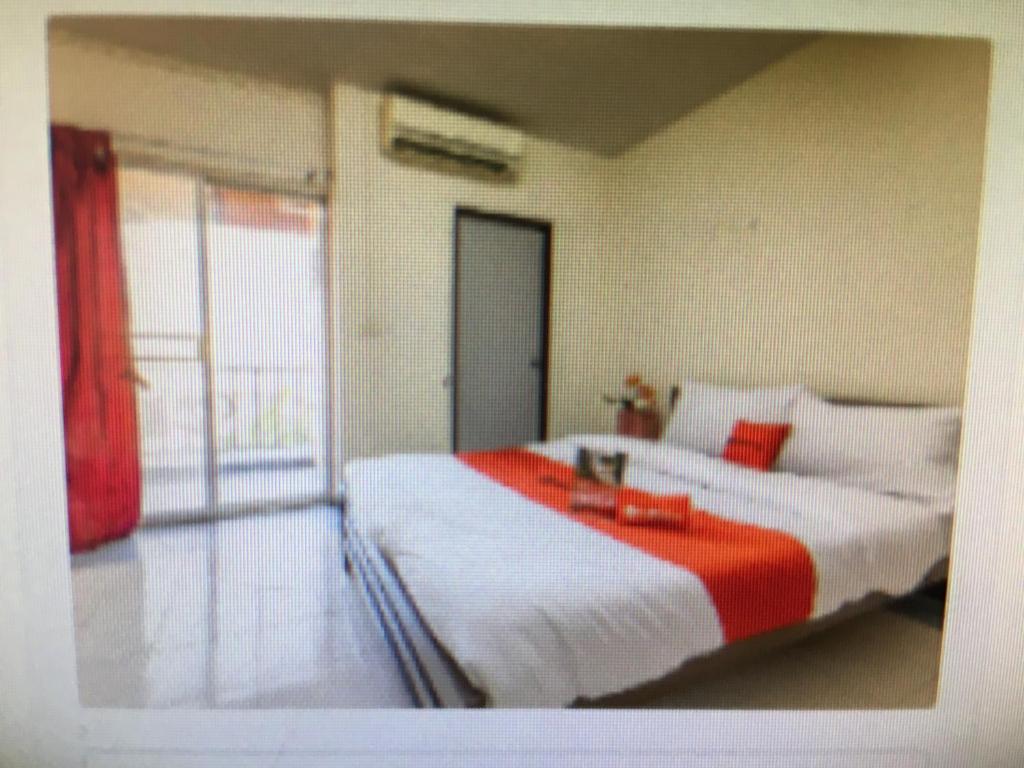 - une chambre dotée d'un lit avec une couverture rouge et blanche dans l'établissement BM Mansion, à Bangna