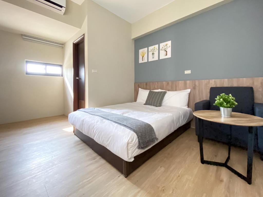 a bedroom with a bed and a table in it at 想想旅居 Allegro Hostel in Taichung